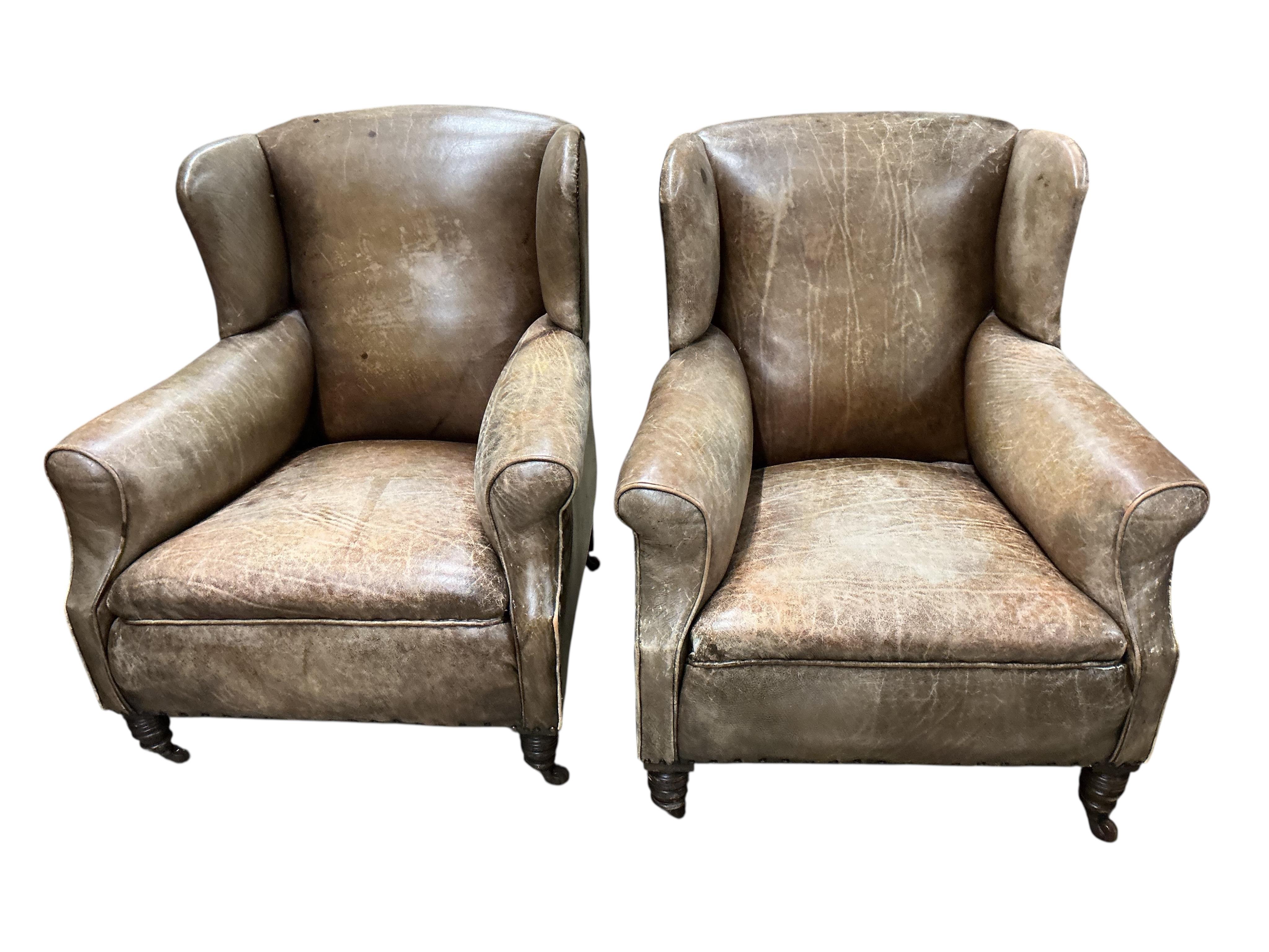 A pair of late Victorian brown leather wing armchairs, width 78cm, depth 76cm, height 89cm
